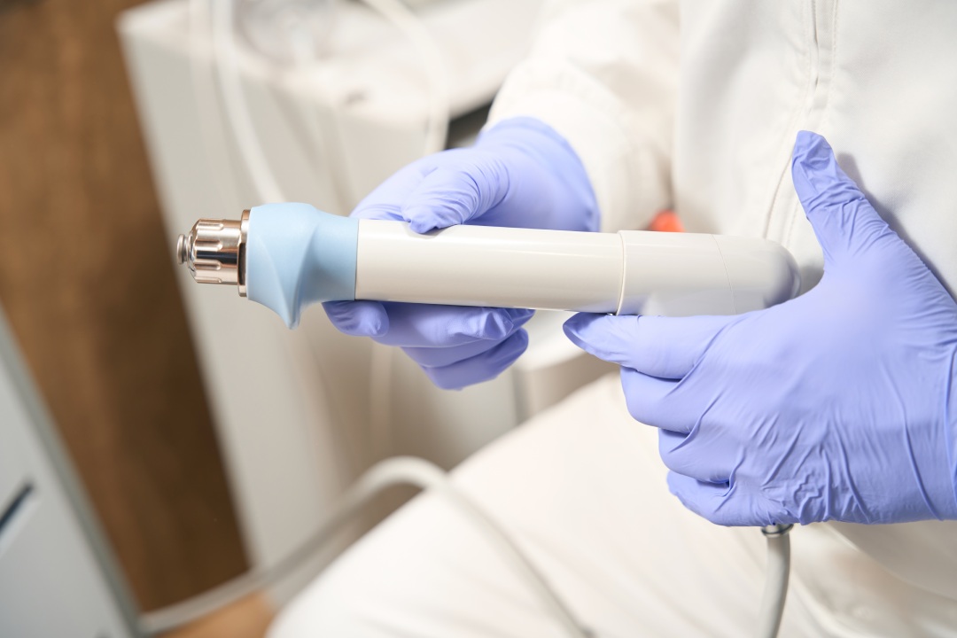 Doctor holding part of shock wave therapy devices in the hospital