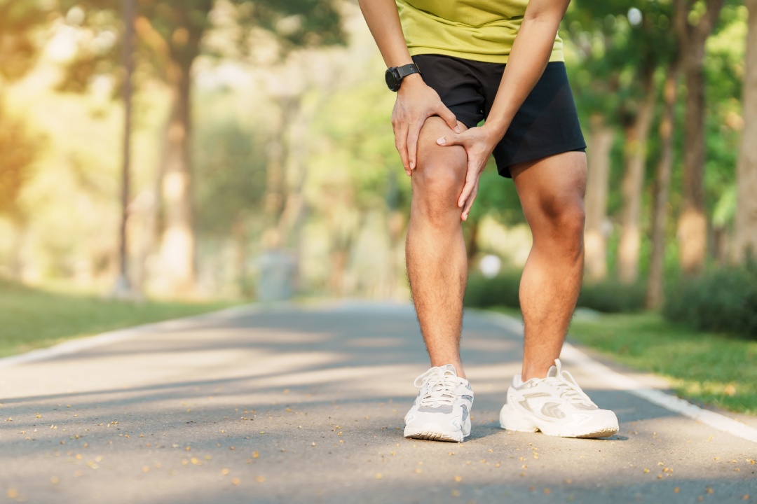 Young adult male with muscle pain during running. runner have knee ache due to Runners Knee or Patellofemoral Pain Syndrome, osteoarthritis and Patellar Tendinitis. Sports injuries and medical concept